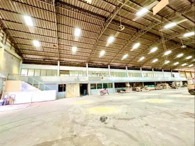 Spacious industrial warehouse with high ceilings and ample natural light.
