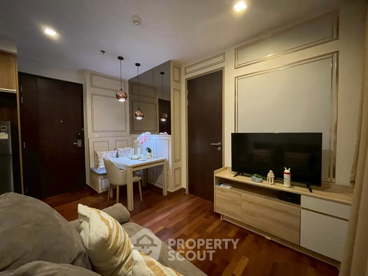 Modern living room with stylish decor and dining area, featuring hardwood floors and ambient lighting.