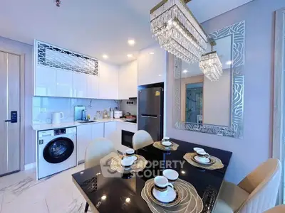Modern kitchen with dining area, featuring sleek appliances and elegant lighting in a stylish apartment.
