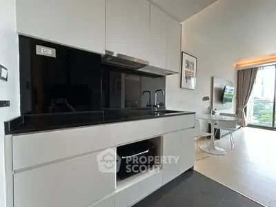 Modern kitchen with sleek black countertops and open layout in stylish apartment