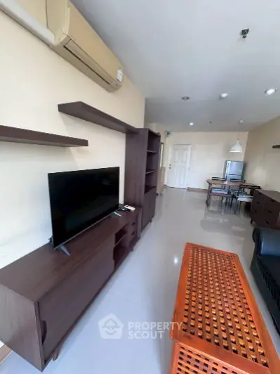 Spacious living room with modern furniture and air conditioning, perfect for relaxation and entertainment.