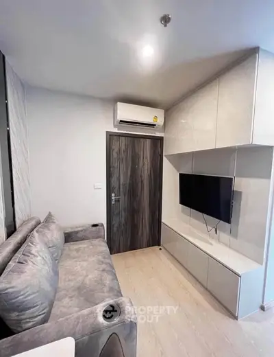 Modern living room with sleek furniture and wall-mounted TV