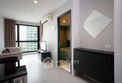 Modern living room with sleek design and city view, featuring stylish furniture and large windows.