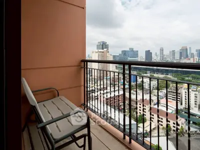 Stunning cityscape view from a high-rise balcony with seating area.