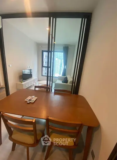 Modern living room with dining table and city view, perfect for urban living.