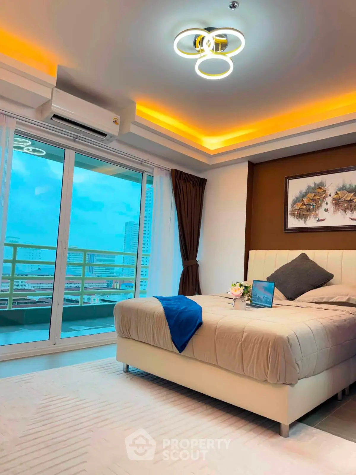 Luxurious bedroom with modern lighting and city view balcony in high-rise apartment.