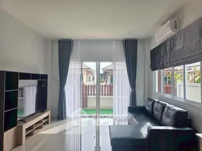 Modern living room with sleek furniture and large windows offering natural light.