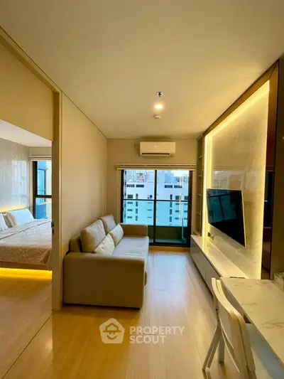 Modern living room with sleek design, featuring a cozy sofa, wall-mounted TV, and a glimpse of a stylish bedroom.