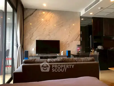 Modern living room with stylish decor and large TV, featuring elegant marble wall and cozy seating area.