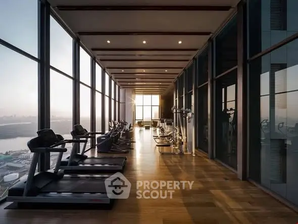 Luxurious high-rise gym with panoramic city views and modern fitness equipment.