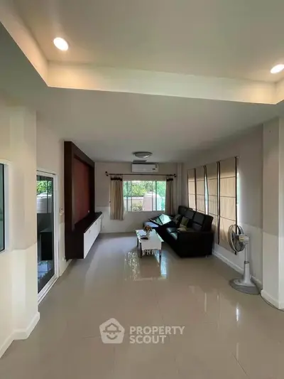 Spacious living room with modern decor and large windows for natural light.