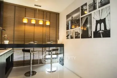 Modern kitchen with sleek design and stylish decor, featuring a breakfast bar and contemporary lighting.