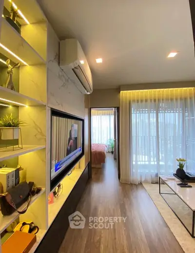 Modern living room with stylish decor and natural light leading to a cozy bedroom.