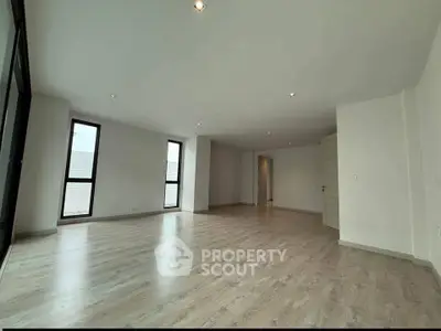 Spacious modern living room with large windows and wooden flooring