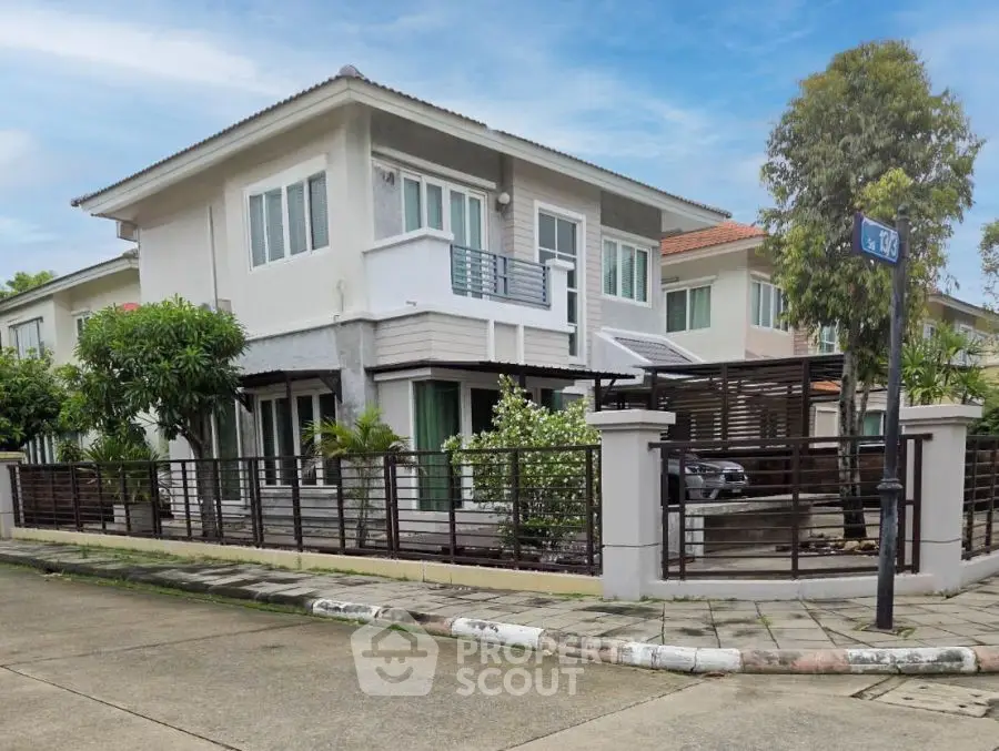 Modern two-story house with sleek design and spacious corner lot in suburban neighborhood.