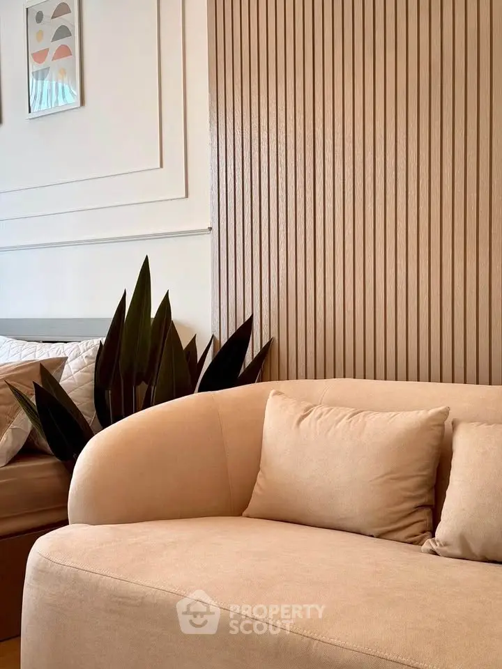 Stylish modern living room with beige sofa and decorative wall panels, perfect for cozy relaxation.