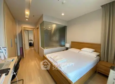 Spacious bedroom with modern design and wooden flooring in a stylish apartment.