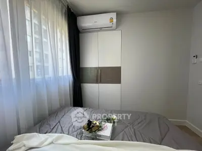 Cozy bedroom with modern air conditioning and stylish wardrobe, perfect for comfortable living.