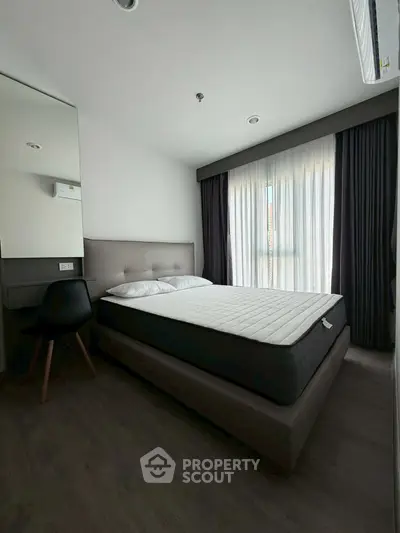 Modern bedroom with sleek design and ample natural light from large window.