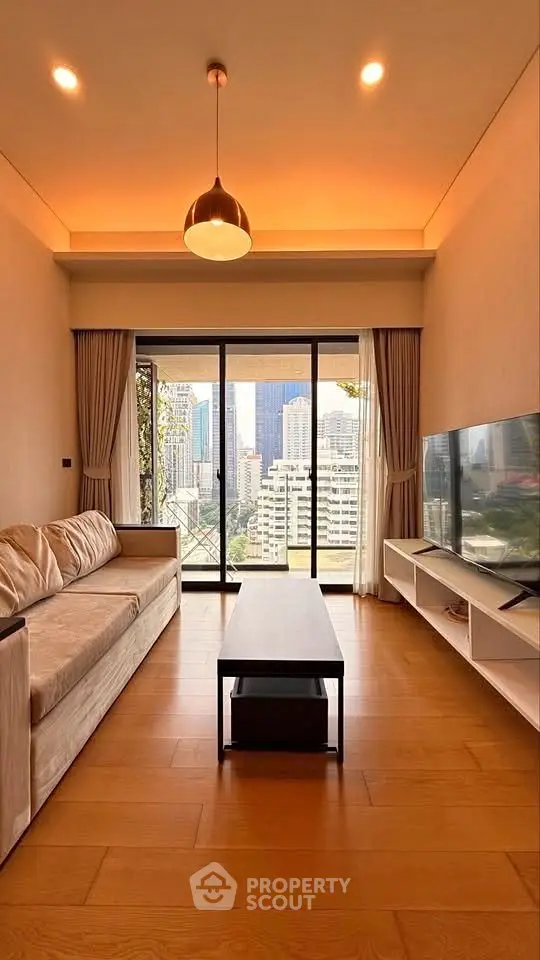 Modern living room with city view, featuring sleek furniture and large windows for natural light.