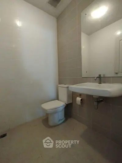 Modern minimalist bathroom with sleek fixtures and neutral tiles.