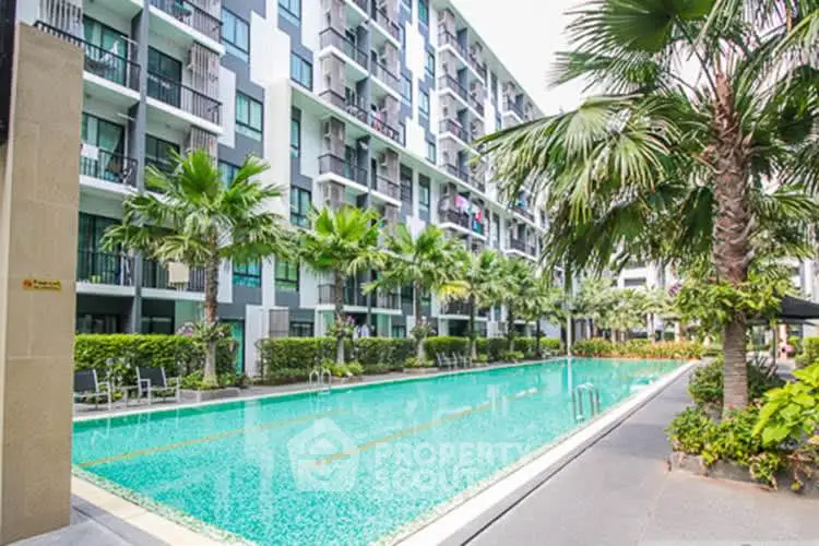 Modern condominium with a stunning outdoor pool and lush palm trees, perfect for luxury living.