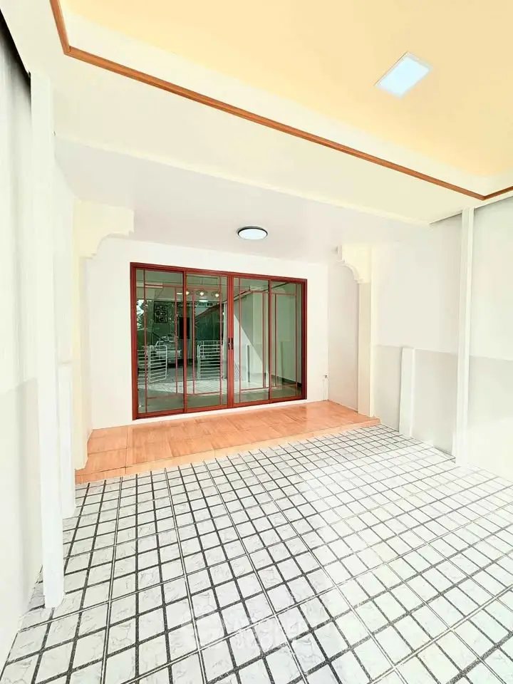 Spacious covered patio with tiled flooring and sliding glass doors.