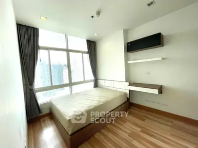 Modern bedroom with large window and city view in high-rise apartment