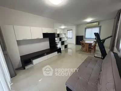 Spacious modern living room with sleek furniture and dining area, perfect for family gatherings.