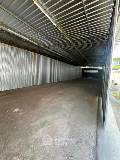 Spacious industrial warehouse with high ceilings and metal walls, ideal for storage or commercial use.
