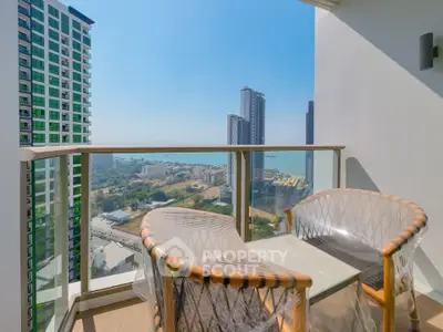 Stunning balcony view with modern chairs overlooking city skyline and ocean.
