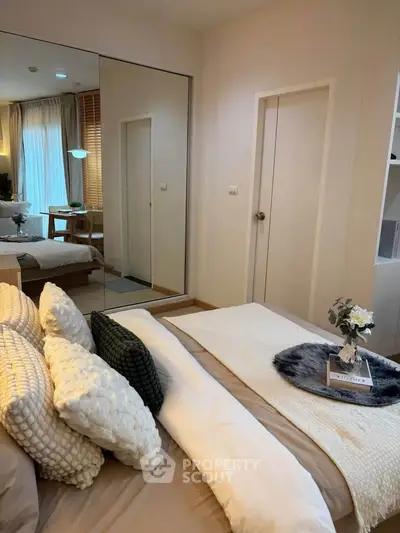 Elegant bedroom with cozy bedding and mirrored wardrobe in modern apartment
