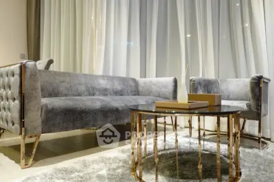 Luxurious modern living room with plush gray sofa and elegant gold-accented coffee table.