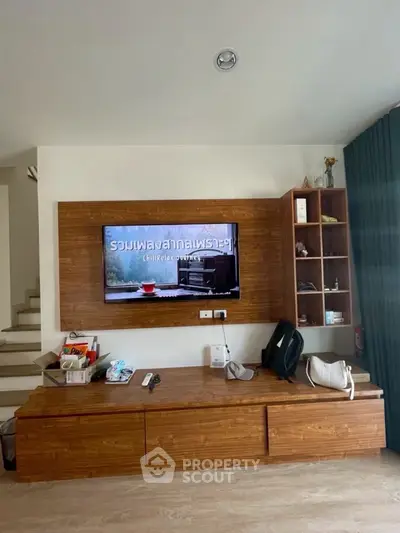 Modern living room with stylish wooden TV unit and staircase
