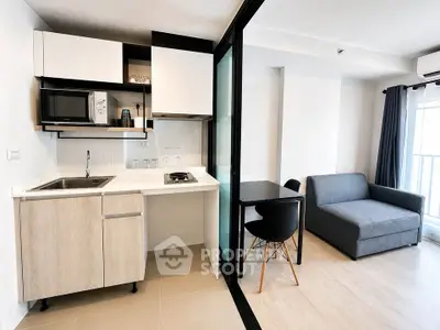 Modern compact kitchen with open layout and cozy living area in a stylish apartment.