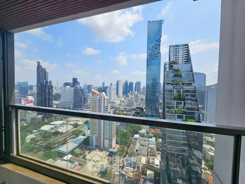 Stunning cityscape view from a high-rise balcony with modern skyscrapers and clear blue sky.