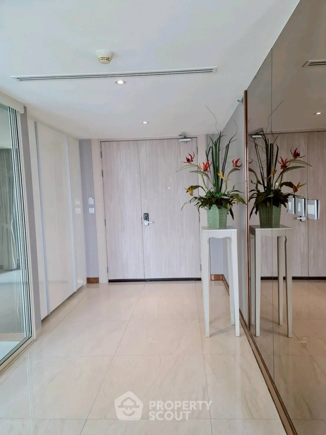 Elegant entrance with mirrored wall and stylish floral arrangement