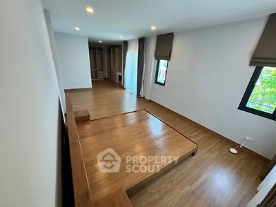 Spacious bedroom with wooden flooring and built-in closet, featuring large windows for natural light.