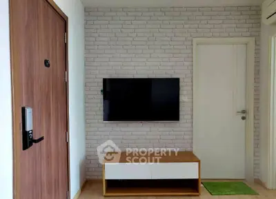 Modern living room with wall-mounted TV and stylish brick accent wall.