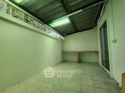 Spacious covered outdoor area with tiled flooring and built-in counter, ideal for versatile use.
