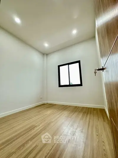 Minimalist bedroom with wooden flooring and natural light