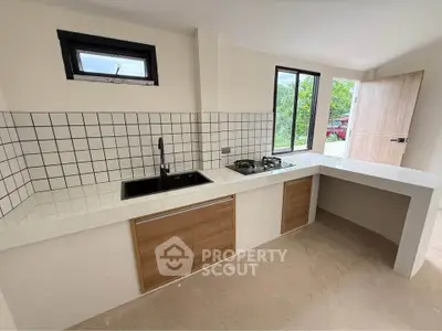 Modern kitchen with sleek design, featuring a gas stove and ample natural light.