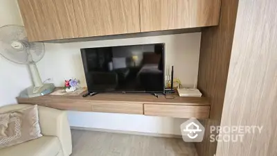 Modern living room with sleek wooden cabinetry and flat-screen TV