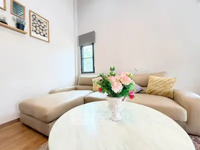 Chic living room with elegant beige sofa and stylish decor in modern apartment.