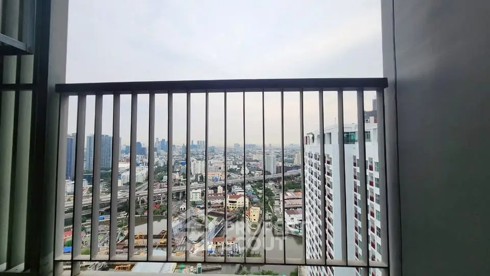 Stunning cityscape view from a high-rise balcony overlooking urban skyline and river.