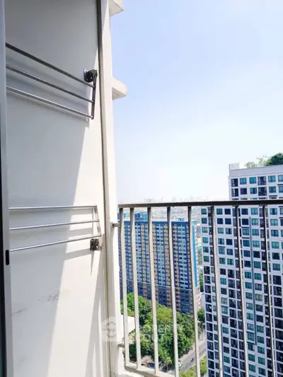Stunning high-rise balcony view with modern cityscape and lush greenery.