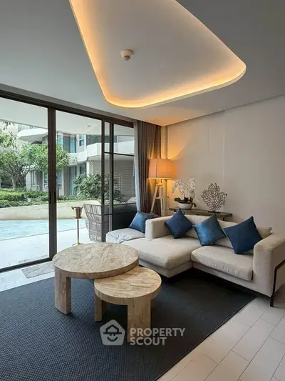 Luxurious living room with modern decor and pool view, featuring elegant furniture and ambient lighting.