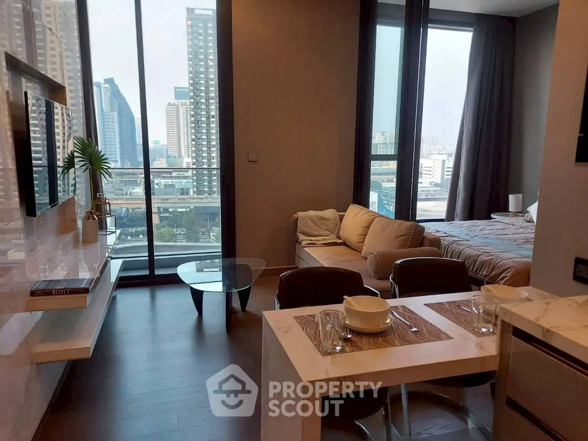 Modern open-plan living room with city view, featuring sleek furniture and large windows.