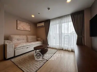 Modern living room with large window and stylish decor in a high-rise apartment.