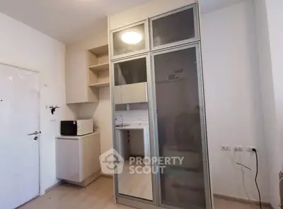 Modern kitchen with sleek cabinetry and microwave in compact space